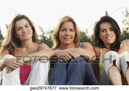 Stock Photo - Portrait of two mid adult women and a mature woman smiling. Fotosearch