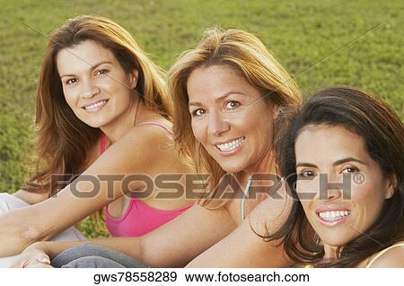 Stock Photo - Portrait of two mid adult women and a mature woman smiling. Fotosearch