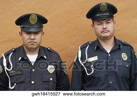 Portrait of two police officers in front of a wall View Large Photo Image Stock Photo - Portrait of two police officers in front of a wall. Fotosearch