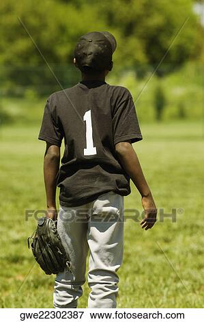 Stock Photo - Rear view of a baseball player holding a baseball glove. Fotosearch