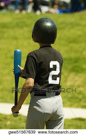 Stock Photo - Rear view of a baseball player holding a baseball bat. Fotosearch