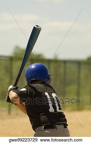 Rear view of a baseball player swinging a baseball bat View Large Photo Image Stock Photo - Rear view of a baseball player swinging a baseball bat. Fotosearch