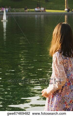 Stock Image - Rear view of a girl near a river. Fotosearch