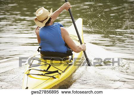 Rear view of a mid adult man kayaking View Large Photo Image Stock Photography - Rear view of a mid adult man kayaking. Fotosearch