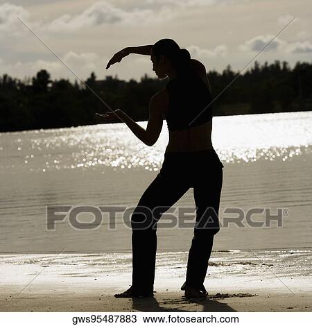 Rear view of a mid adult woman exercising on the beach View Large Photo Image Stock Image - Rear view of a mid adult woman exercising on the beach. Fotosearch