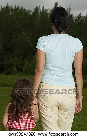 Rear view of a mother holding her daughter's hand View Large Photo Image Stock Image - Rear view of a mother holding her daughter's hand. Fotosearch