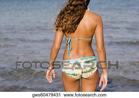 Rear view of a teenage girl standing on the beach View Large Photo Image Stock Image - Rear view of a teenage girl standing on the beach. Fotosearch