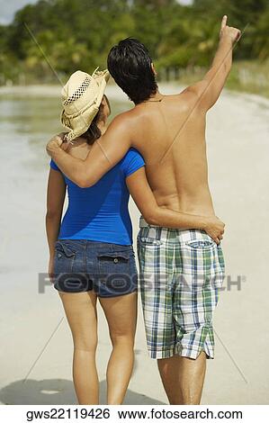 Rear view of a teenage girl with her arm around a young man View Large Photo Image Stock Photograph - Rear view of a teenage girl with her arm around a young man. Fotosearch