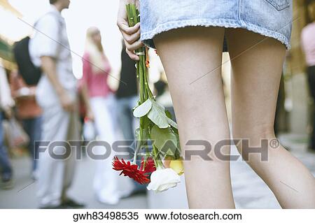 Rear view of a woman holding a bouquet of flowers View Large Photo Image Stock Photography - Rear view of a woman holding a bouquet of flowers . Fotosearch