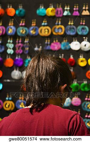 Rear view of a woman looking at earrings View Large Photo Image Picture - Rear view of a woman looking at earrings. Fotosearch