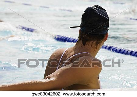 Rear view of a young woman in a swimming pool View Large Photo Image Stock Image - Rear view of a young woman in a swimming pool. Fotosearch