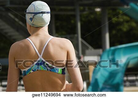 Picture - Rear view of a young woman wearing a swimming cap. Fotosearch