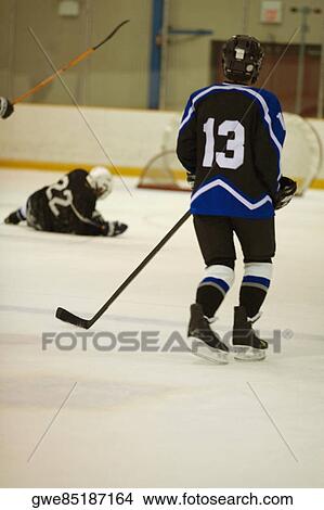 Picture - Rear view of an ice hockey player playing ice hockey. Fotosearch