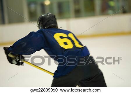 Rear view of an ice hockey player playing ice hockey View Large Photo Image Stock Image - Rear view of an ice hockey player playing ice hockey. Fotosearch