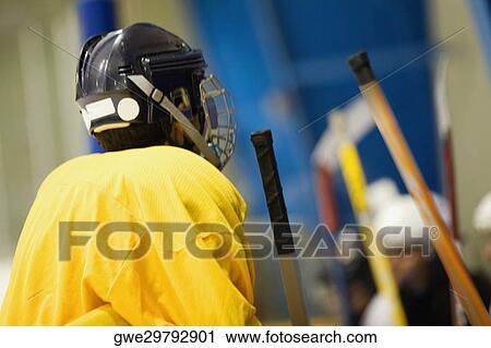 Stock Image - Rear view of an ice hockey player wearing a helmet. Fotosearch