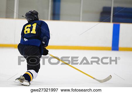 Stock Photo - Rear view of an ice hockey player playing ice hockey. Fotosearch