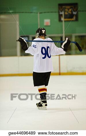 Stock Photo - Rear view of an ice hockey player holding an ice hockey stick. Fotosearch
