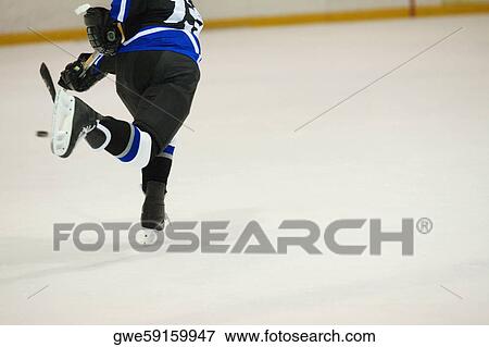 Rear view of an ice hockey player playing ice hockey View Large Photo Image Stock Photo - Rear view of an ice hockey player playing ice hockey. Fotosearch