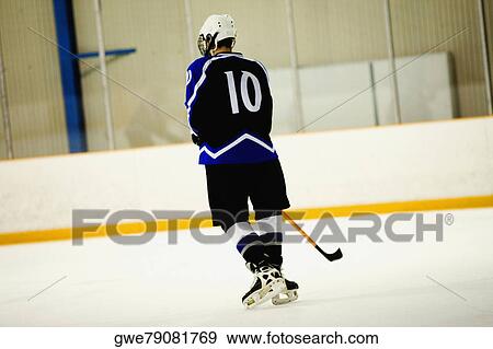 Rear view of an ice hockey player playing ice hockey View Large Photo Image Stock Photo - Rear view of an ice hockey player playing ice hockey. Fotosearch