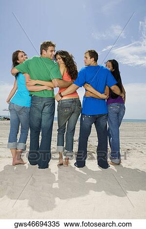 Rear view of five people standing on the beach View Large Photo Image Stock Photography - Rear view of five people standing on the beach. Fotosearch