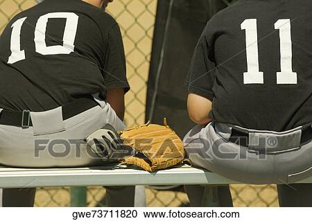 Rear view of two baseball players sitting on a bench View Large Photo Image Stock Image - Rear view of two baseball players sitting on a bench. Fotosearch