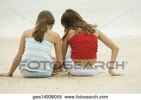 Rear view of two girls sitting on the beach View Large Photo Image Stock Photography - Rear view of two girls sitting on the beach. Fotosearch