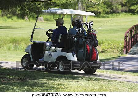 Stock Photo - Rear view of two men on a golf cart. Fotosearch