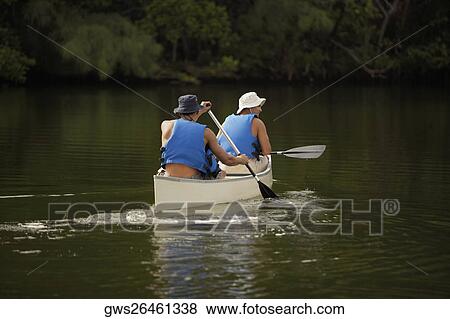 Rear view of two mid adult men canoeing View Large Photo Image Stock Photo - Rear view of two mid adult men canoeing. Fotosearch