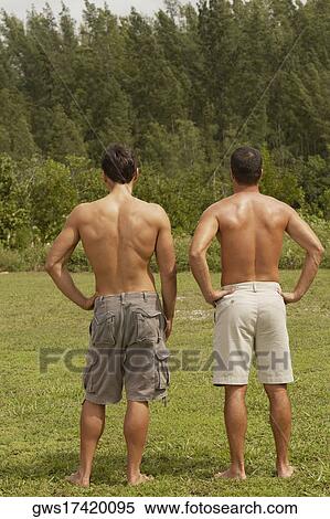 Rear view of two mid adult men with arms akimbo View Large Photo Image Stock Photography - Rear view of two mid adult men with arms akimbo. Fotosearch