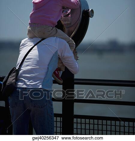 Rear view of two people near coin-operated binoculars, New York City, New York State, USA View Large Photo Image Stock Photo - Rear view of two people near coin-operated binoculars, New York City, New York State, USA. Fotosearch