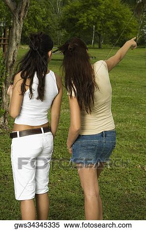 Rear view of two teenage girls standing in the garden View Large Photo Image Stock Photography - Rear view of two teenage girls standing in the garden. Fotosearch