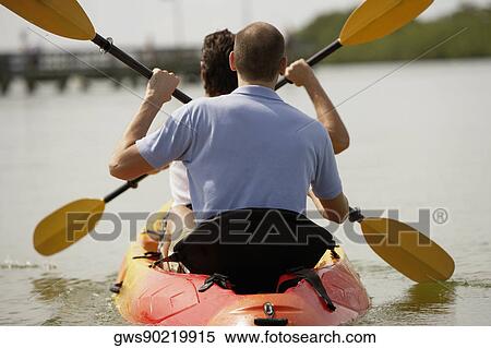 Rear view of two young men kayaking View Large Photo Image Stock Photography - Rear view of two young men kayaking. Fotosearch