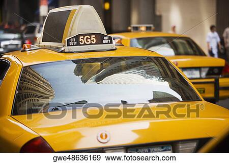 Stock Photo - Reflection of buildings on the windshield of a yellow taxi, New York City, New York State, USA. Fotosearch