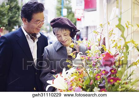 Senior man and a mature woman looking at flowers View Large Photo Image Stock Photo - Senior man and a mature woman looking at flowers . Fotosearch