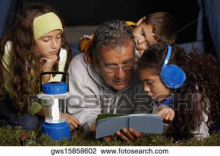 Senior man reading a book to his three grandchildren View Large Photo Image Stock Image - Senior man reading a book to his three grandchildren. Fotosearch