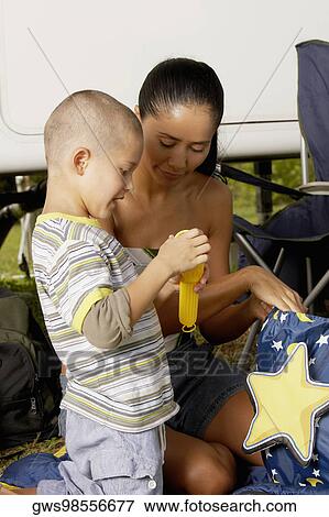 Side profile of a boy and his mother holding a flashlight View Large Photo Image Stock Photo - Side profile of a boy and his mother holding a flashlight. Fotosearch