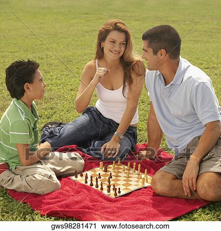 Side profile of a boy sitting with his parents and playing chess View Large Photo Image Stock Image - Side profile of a boy sitting with his parents and playing chess. Fotosearch