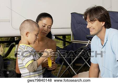 Side profile of a boy with his parents holding a flashlight View Large Photo Image Stock Photo - Side profile of a boy with his parents holding a flashlight. Fotosearch