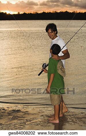 Stock Image - Side profile of a father and his son fishing. Fotosearch