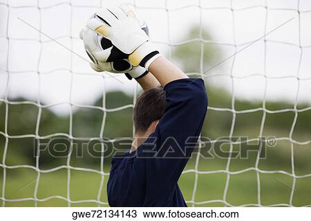Side profile of a goalie holding a soccer ball over his head View Large Photo Image Stock Image - Side profile of a goalie holding a soccer ball over his head. Fotosearch