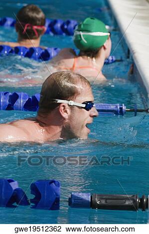 Stock Image - Side profile of a mid adult man in a swimming pool. Fotosearch