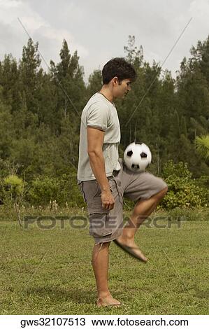 Side profile of a mid adult man playing with a soccer ball View Large Photo Image Stock Image - Side profile of a mid adult man playing with a soccer ball. Fotosearch