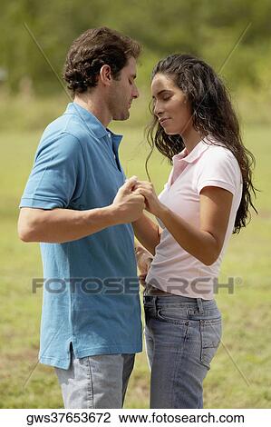 Side profile of a mid adult man standing and holding a young woman's hand View Large Photo Image Stock Image - Side profile of a mid adult man standing and holding a young woman's hand. Fotosearch