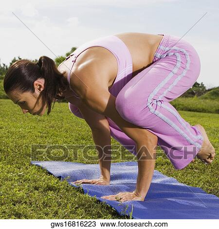Stock Image - Side profile of a mid adult woman in a yoga position. Fotosearch