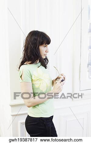 Side profile of a mid adult woman holding a glass View Large Photo Image Stock Photo - Side profile of a mid adult woman holding a glass. Fotosearch