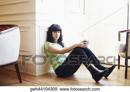 Side profile of a mid adult woman leaning against a wall and holding a glass View Large Photo Image Stock Photo - Side profile of a mid adult woman leaning against a wall and holding a glass. Fotosearch