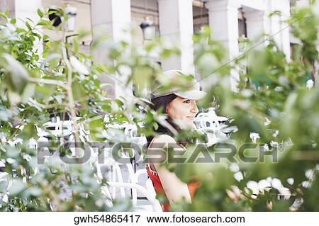 Stock Photo - Side profile of a mid adult woman sitting in a restaurant . Fotosearch