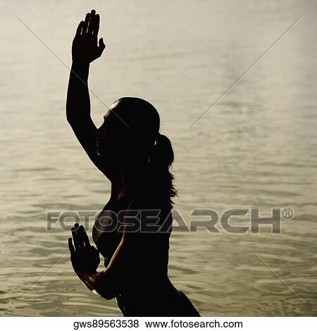 Side profile of a mid adult woman standing in water View Large Photo Image Stock Photo - Side profile of a mid adult woman standing in water. Fotosearch
