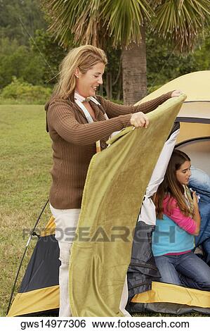 Side profile of a mid adult woman holding a blanket with her daughter near a tent View Large Photo Image Stock Photograph - Side profile of a mid adult woman holding a blanket with her daughter near a tent. Fotosearch