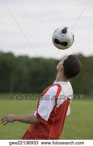 Side profile of a soccer player heading a ball View Large Photo Image Stock Image - Side profile of a soccer player heading a ball. Fotosearch